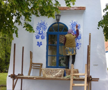 FOTO: O bunicuta picteaza cladirile din satul ei in motive traditional