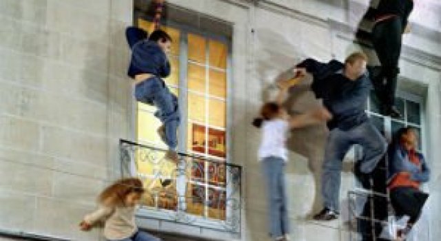 Iluzie vizuala: O cladire inalta si membrii unei familii atarnati la ferestre
